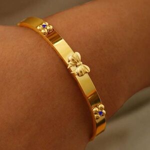 Gold plated stainless steel bow & clover bangle bracelet